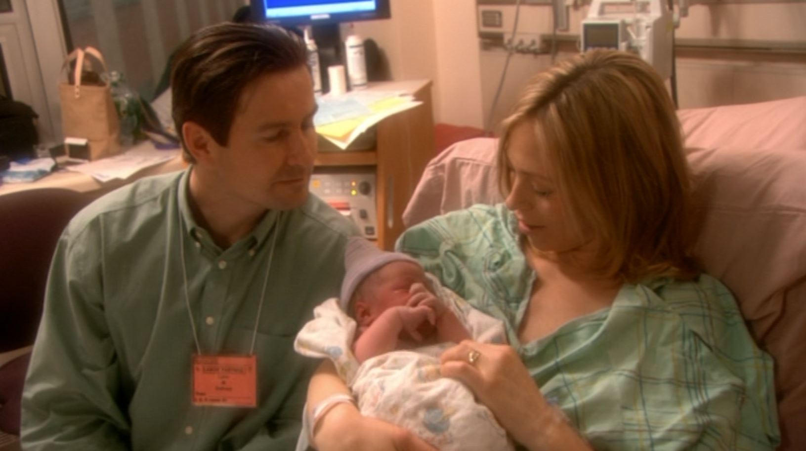 Two parents looking at their newborn baby in the hospital