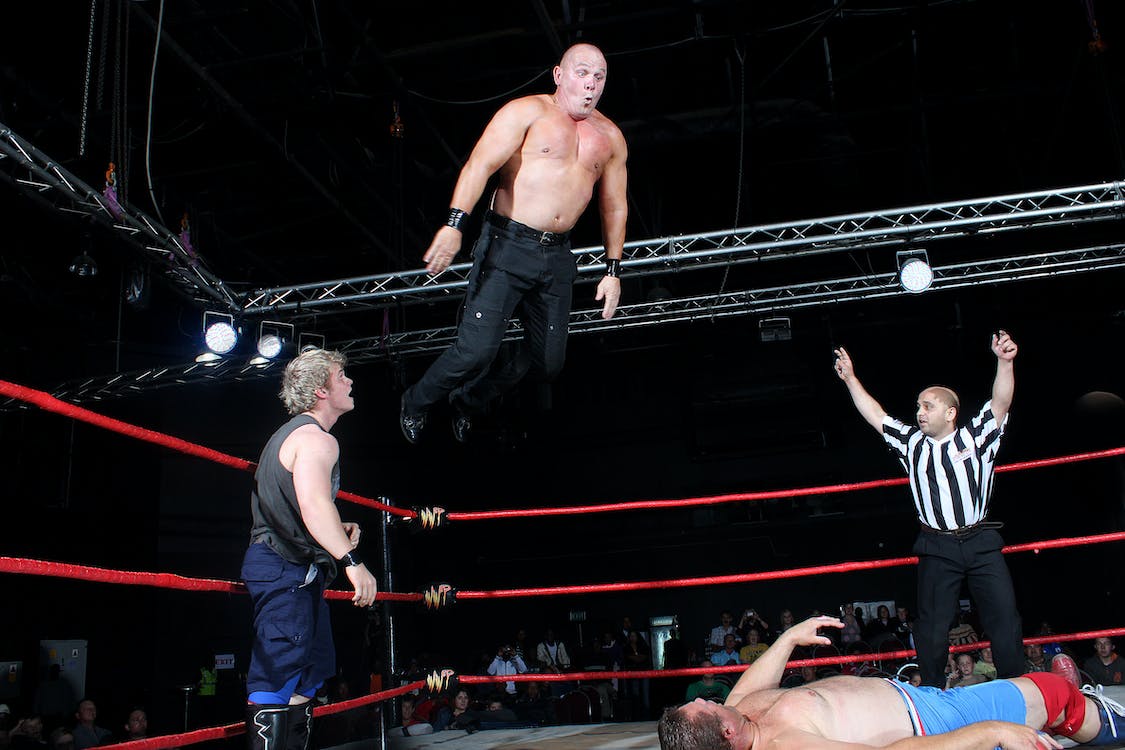 A man about to land on another in a wrestling match