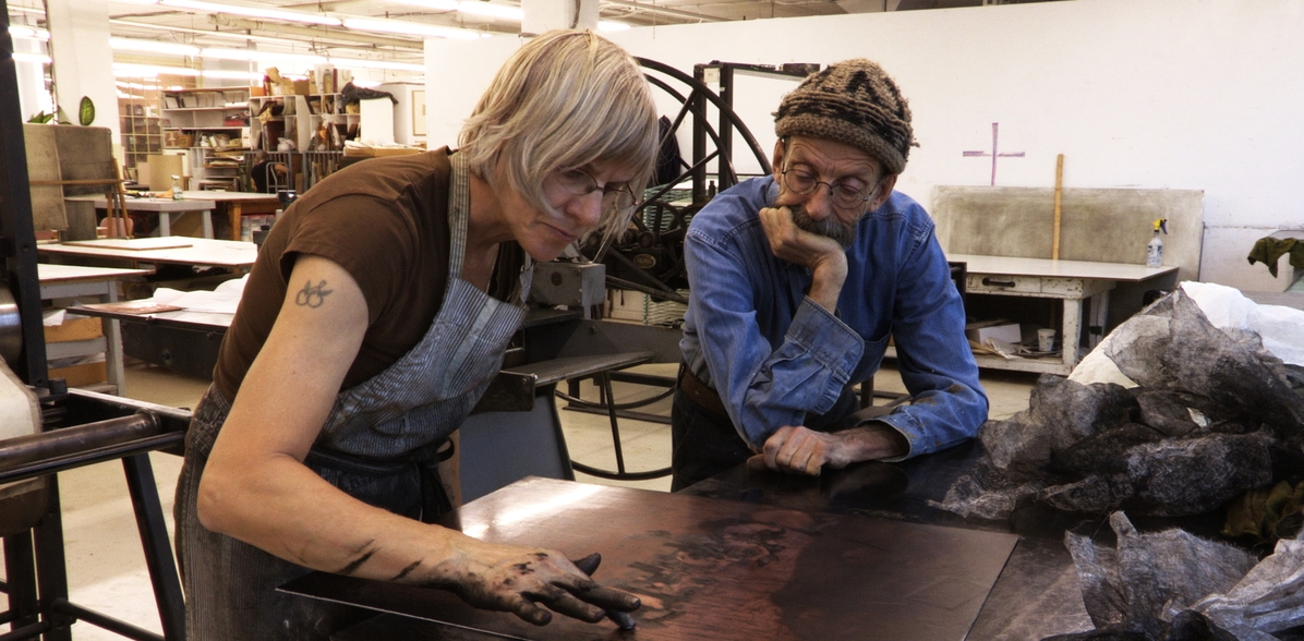 Two old folks finger paiting a portrait