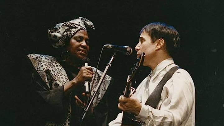 a woman in a hat and a man with a guitar sing together