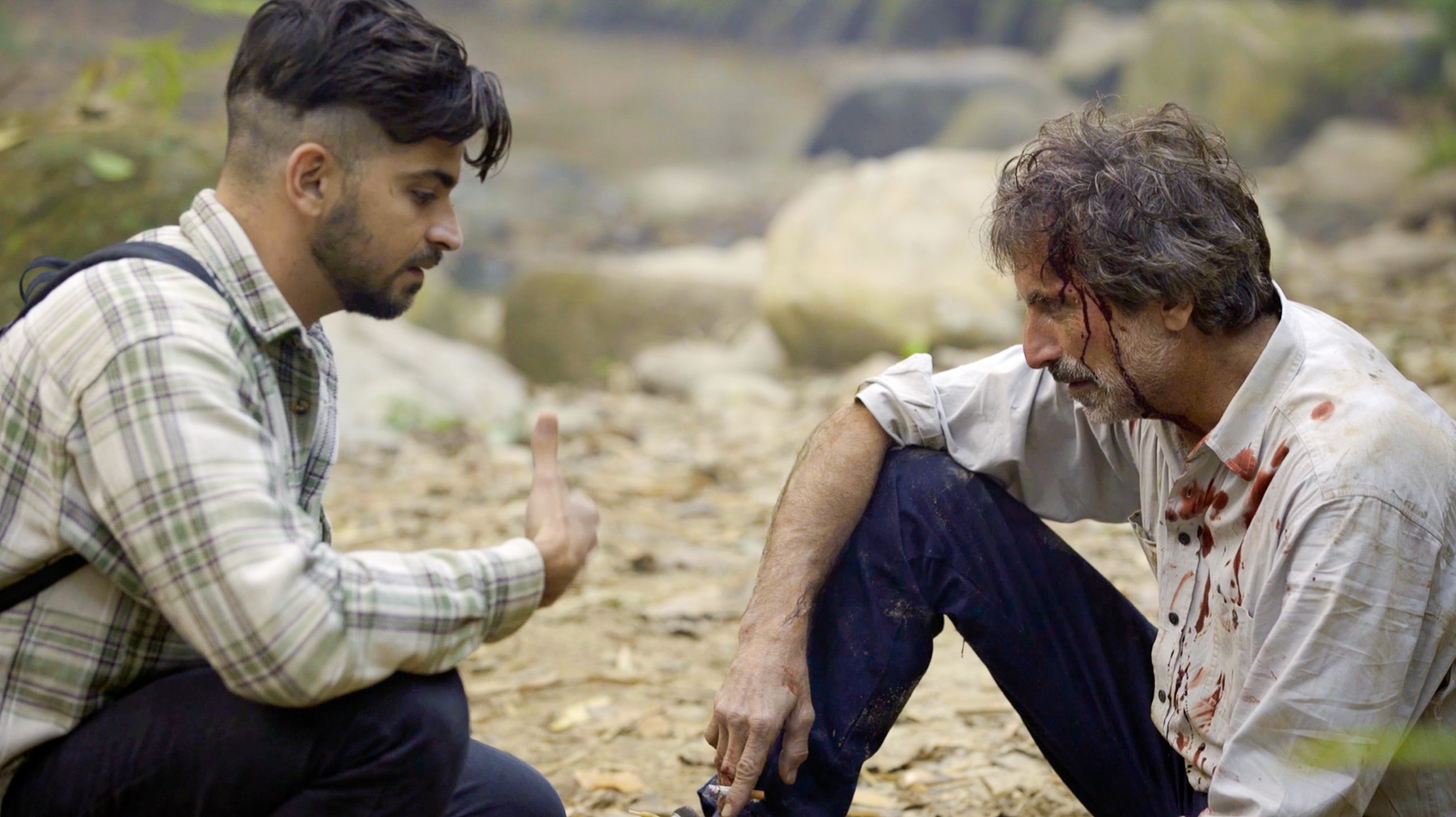 two men in profile looking into each other's eyes, one of them bloodied