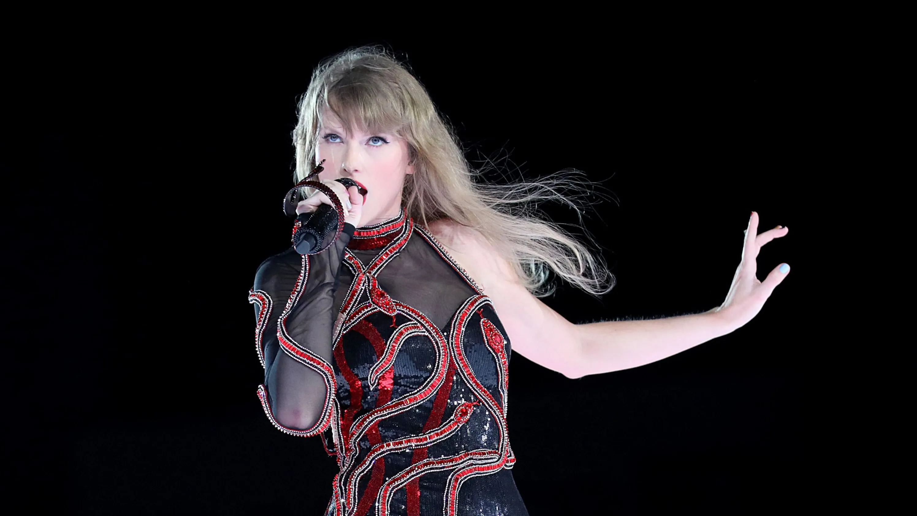 a blonde woman sings with a microphone