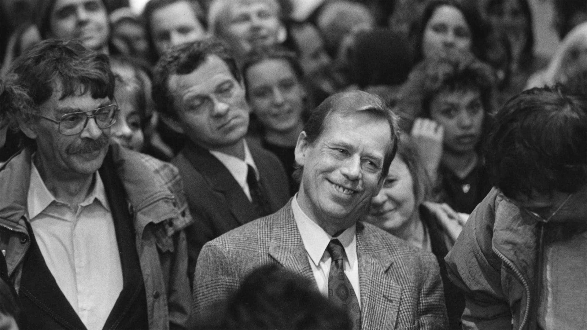 a blond man smiles around other people