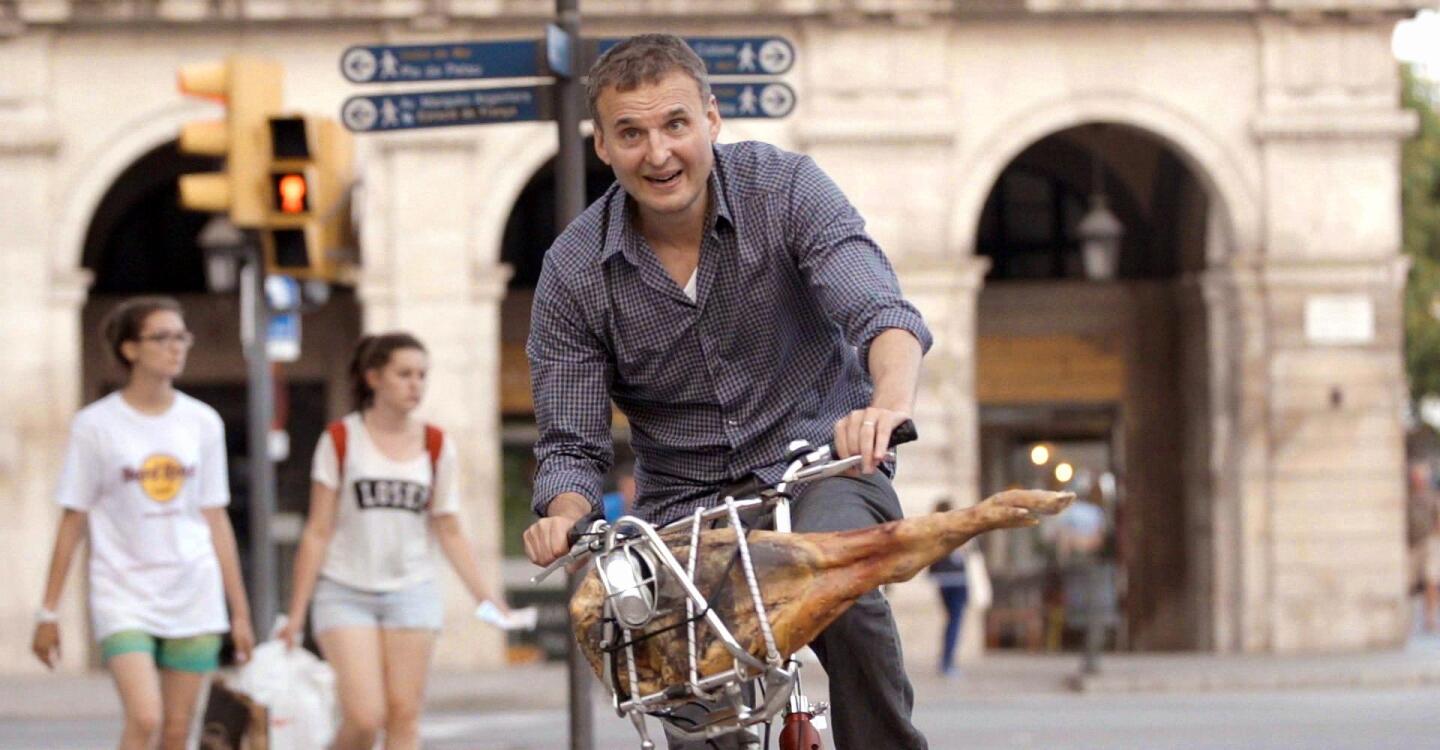 man on a bicycle with a leg of Serrano ham