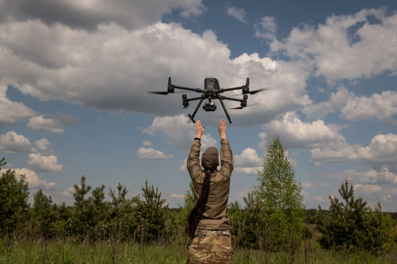 a long-haired military woman with a drone in her hands
