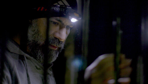 mustachioed man with a flashlight on his head