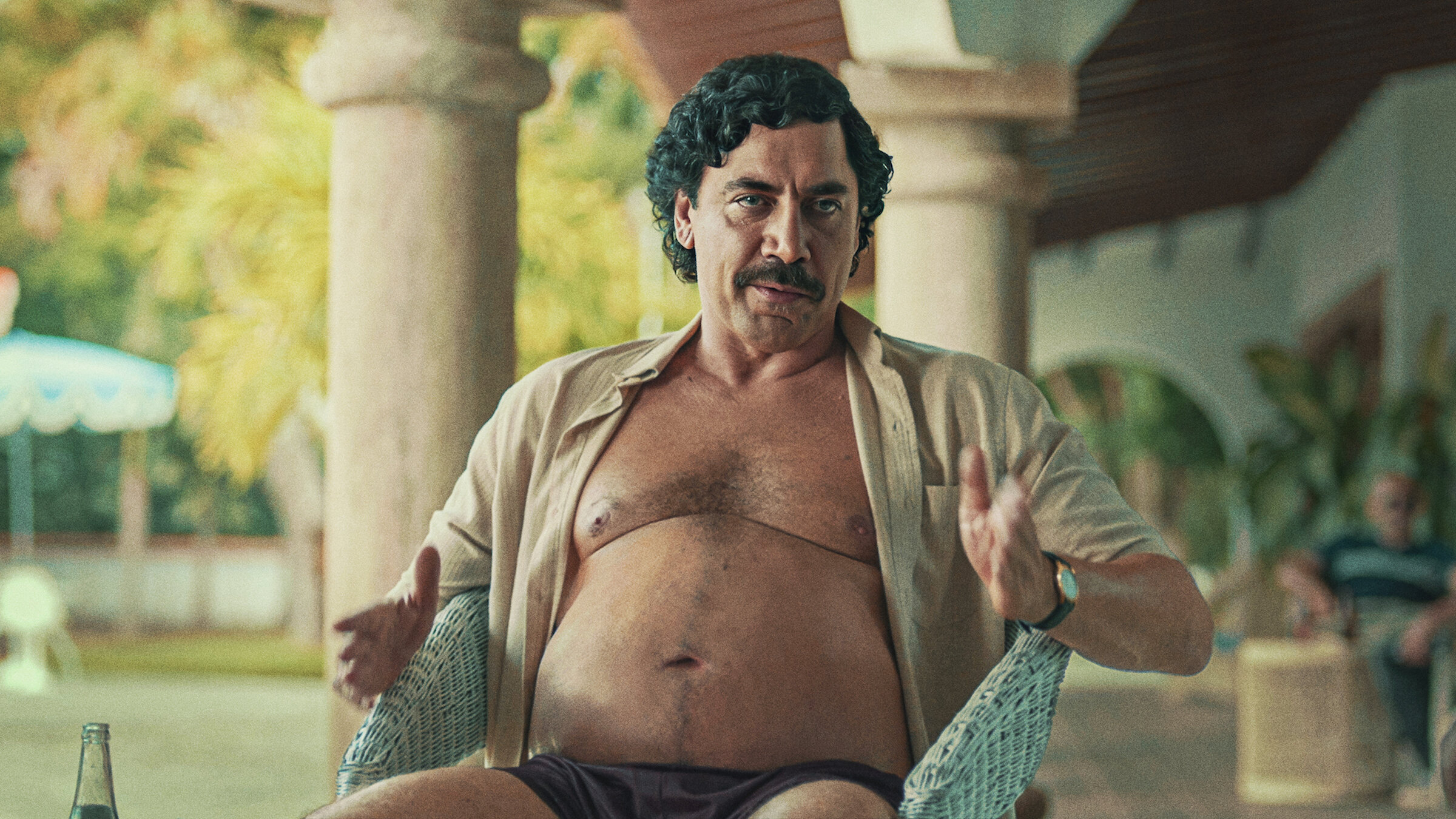 dark-haired, mustachioed man with open shirt shows his belly