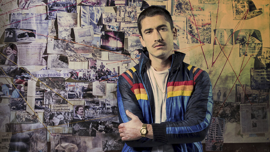 young man in a jacket and dark hair with his arms crossed