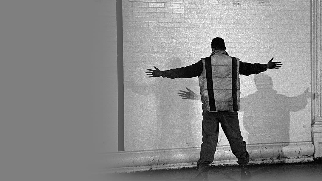 a man in a tracksuit raises his hands