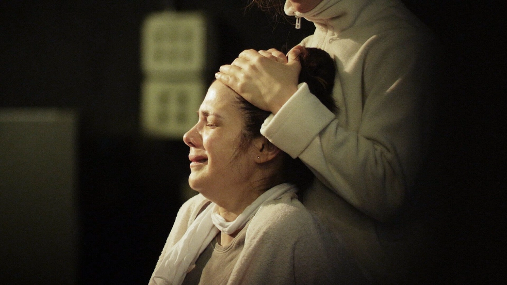 A suffering woman is subdued by another